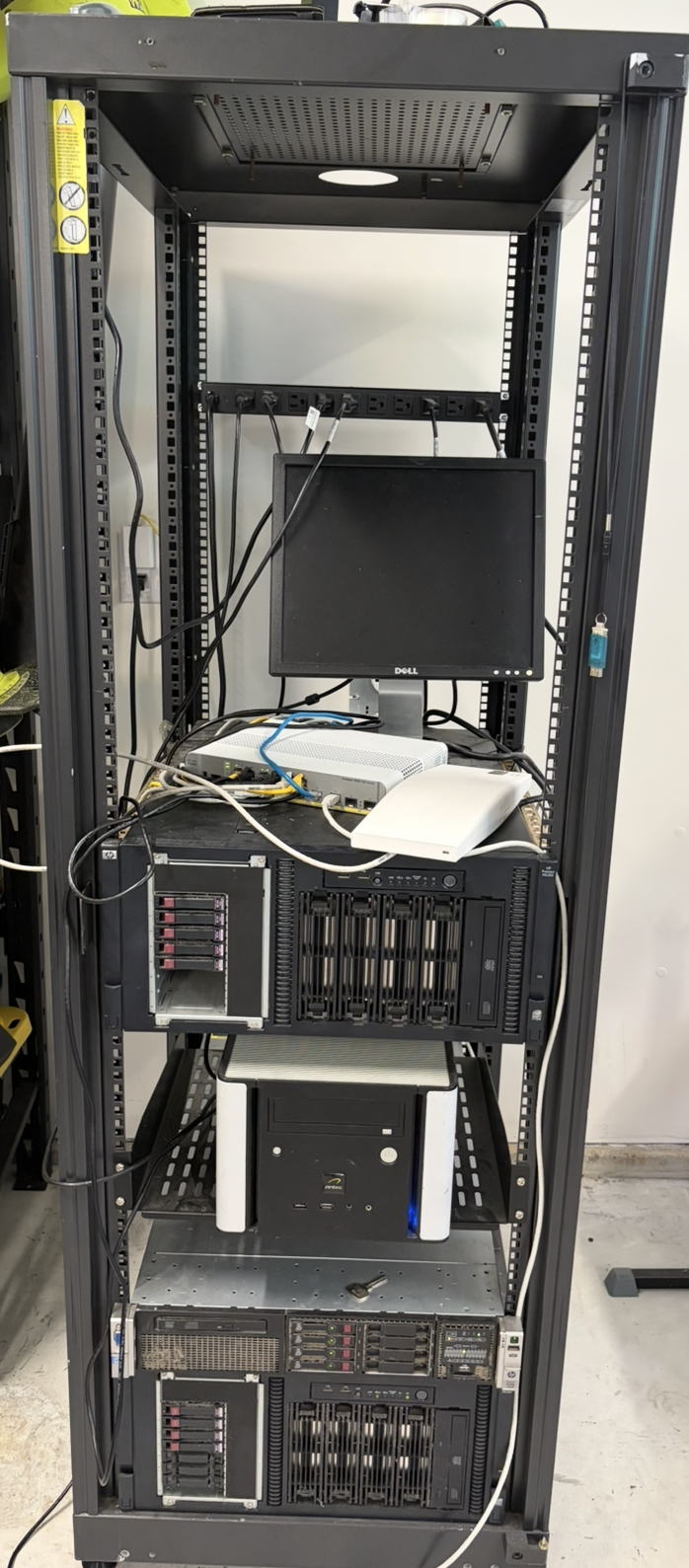 The home lab rack: server, NAS box, managed switch, and wireless AP, all stacked and cabled up